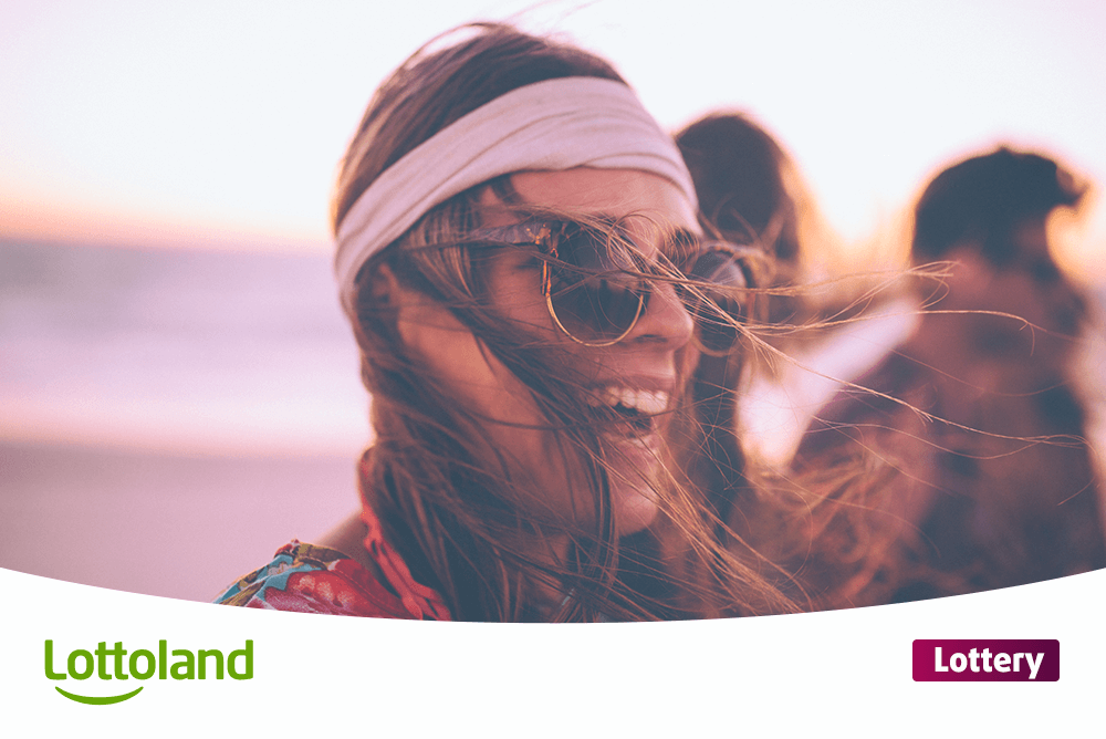 Happy woman wearing sunglasses on the beach at sunset